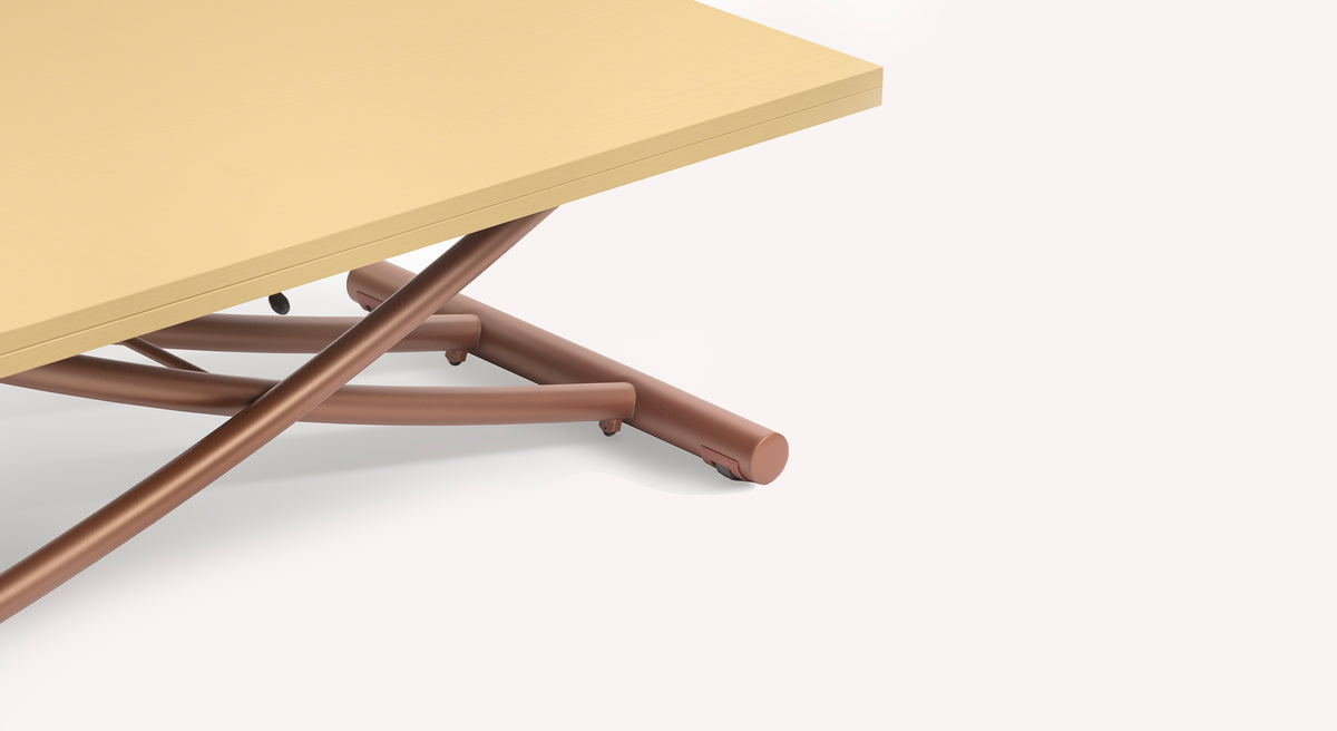 Détail d'une table extensible Bessy avec plateau beige et pieds croisés en métal brun