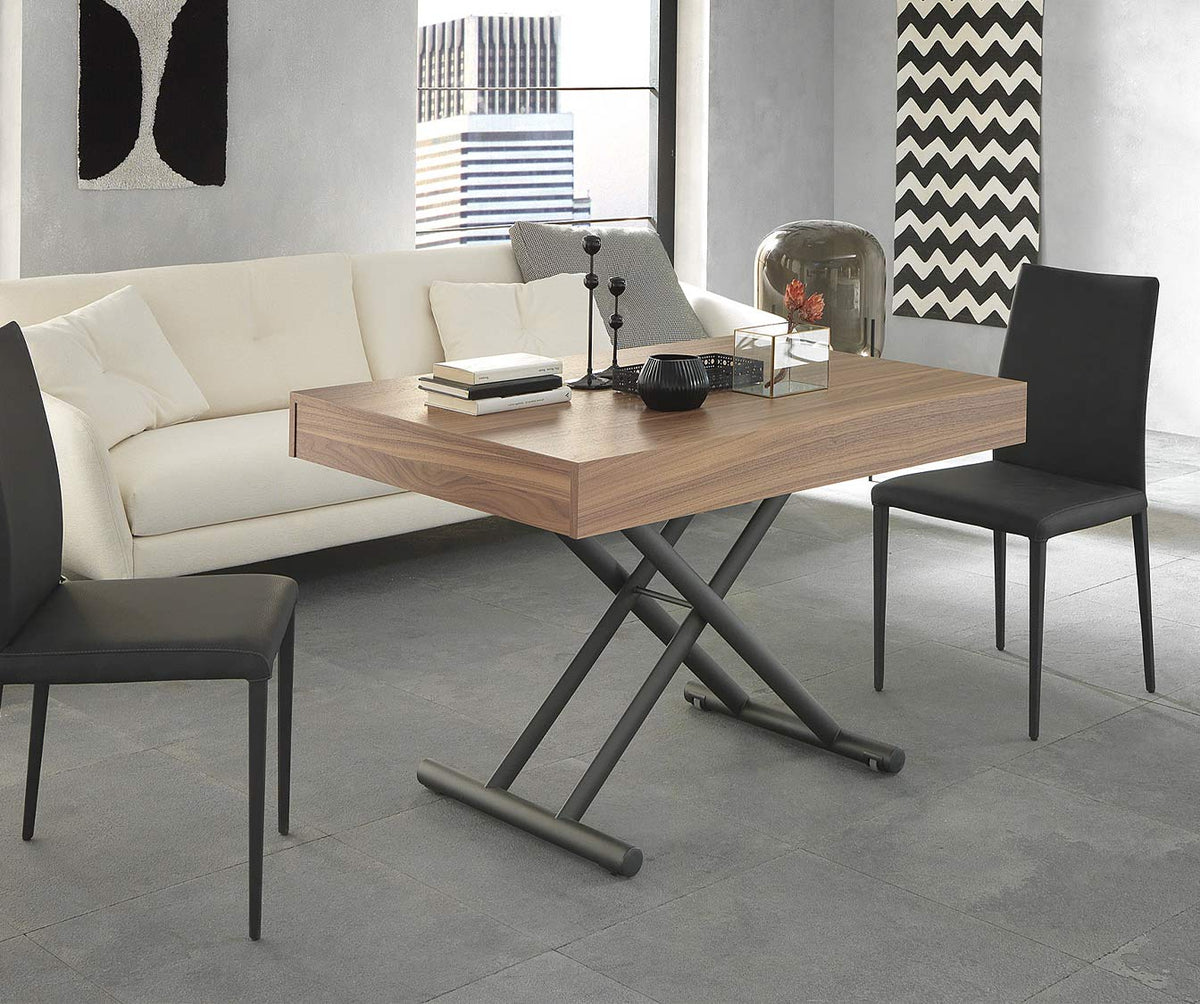 Table extensible moderne en bois plaqué noyer canaletto avec structure métallique noire, dans un salon contemporain avec canapé blanc et chaises noires, modèle BOSTON Plaqué Noyer canaletto.
