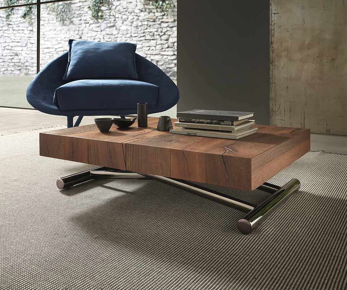 Table basse en CALYPSO Bois Massif Termotrattato avec plateau en bois massif finition naturelle et pieds en métal chromé, présentée dans un salon contemporain avec fauteuil bleu.