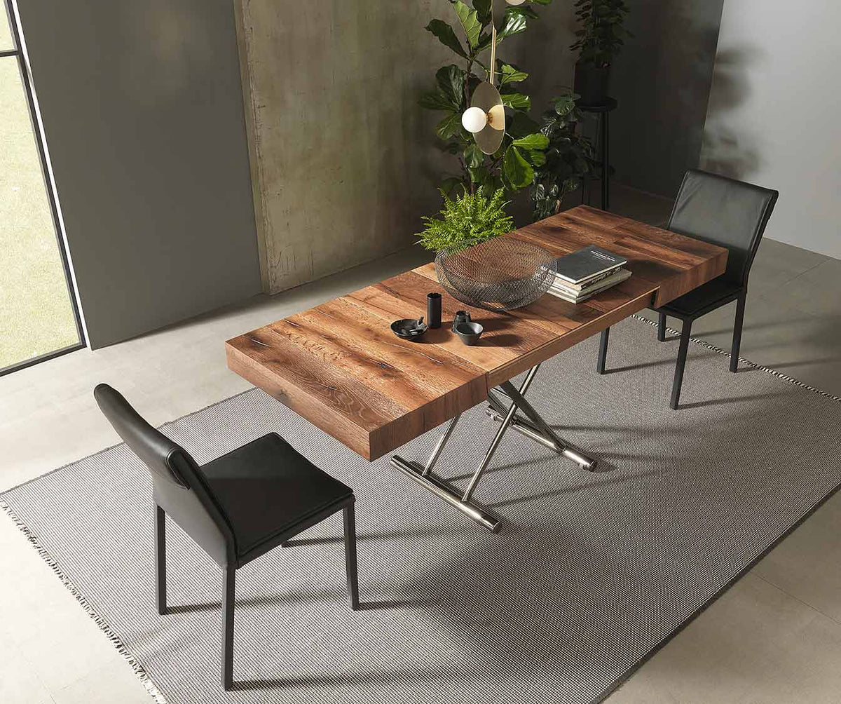 Table extensible en CALYPSO Bois Massif Termotrattato avec plateau en bois chaleureux et piètement métallique, entourée de chaises modernes dans un salon lumineux.