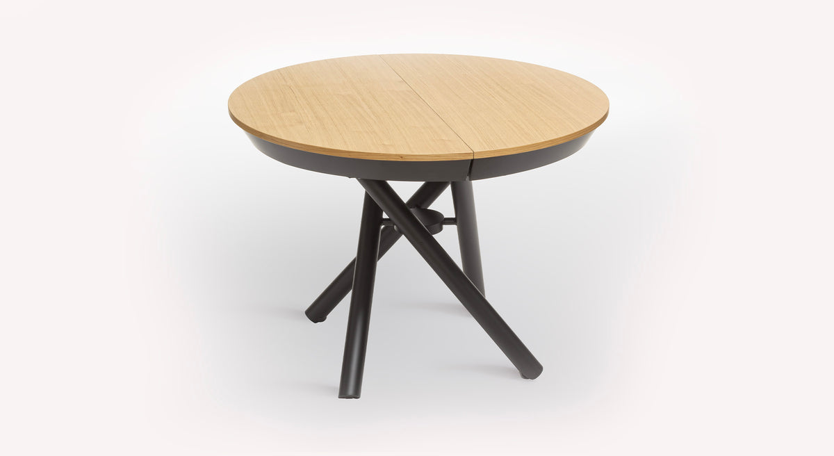 Table ronde relevable Helios avec plateau en bois clair et pieds croisés noirs
