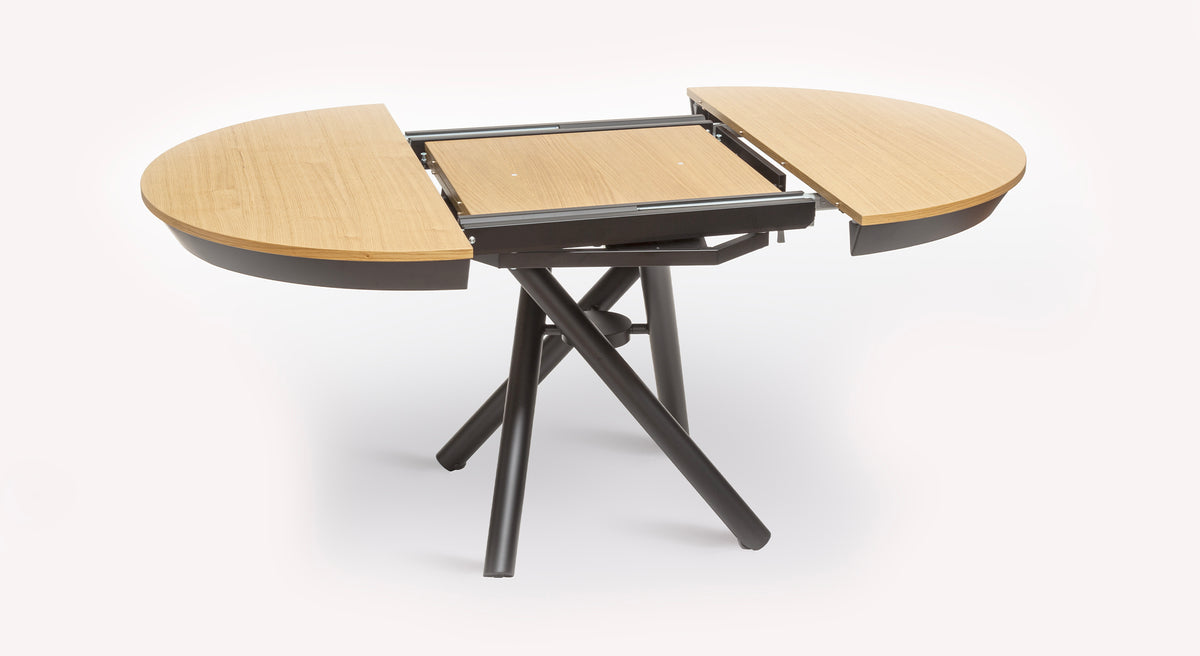 Table relevable Helios en bois clair avec mécanisme d'extension central et pieds en métal noir croisés