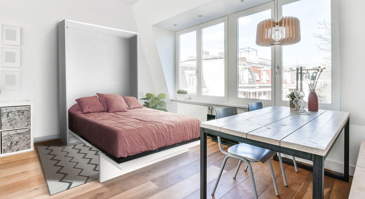 Lit escamotable ouvert dans une pièce lumineuse avec table en bois, chaises et décoration moderne