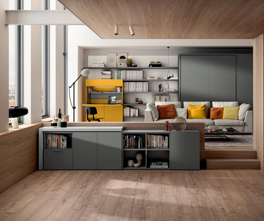 Salon moderne avec canapé gris clair, coussins colorés et meuble bas gris, dans un espace lumineux et épuré mettant en valeur le modèle GIRO +50 coloris & matériaux.