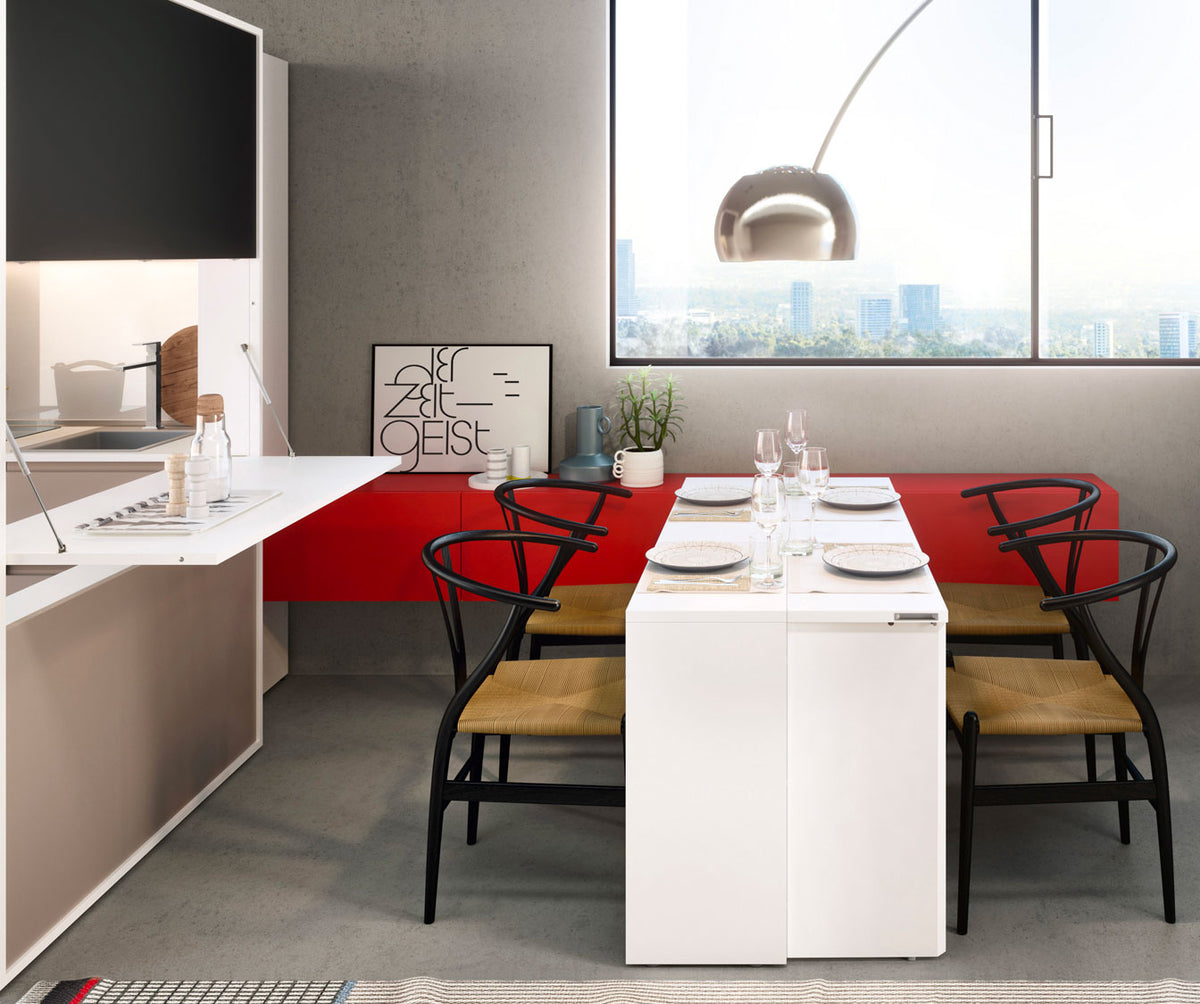 Salle à manger moderne avec table extensible blanche entourée de chaises noires et assises en bois clair, décor minimaliste et vue urbaine, modèle GIRO +50 coloris & matériaux.