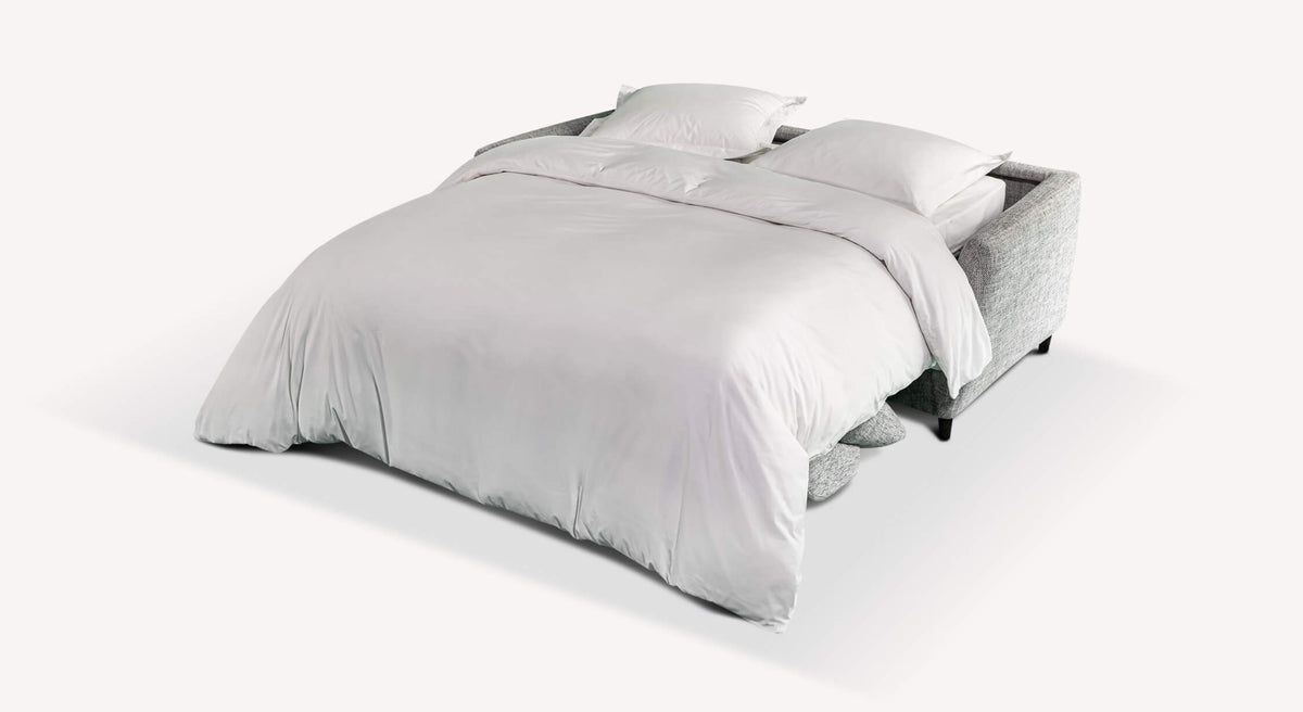 Canapé convertible en tissu étain, modèle Bow, ouvert en position lit avec draps blancs et oreillers