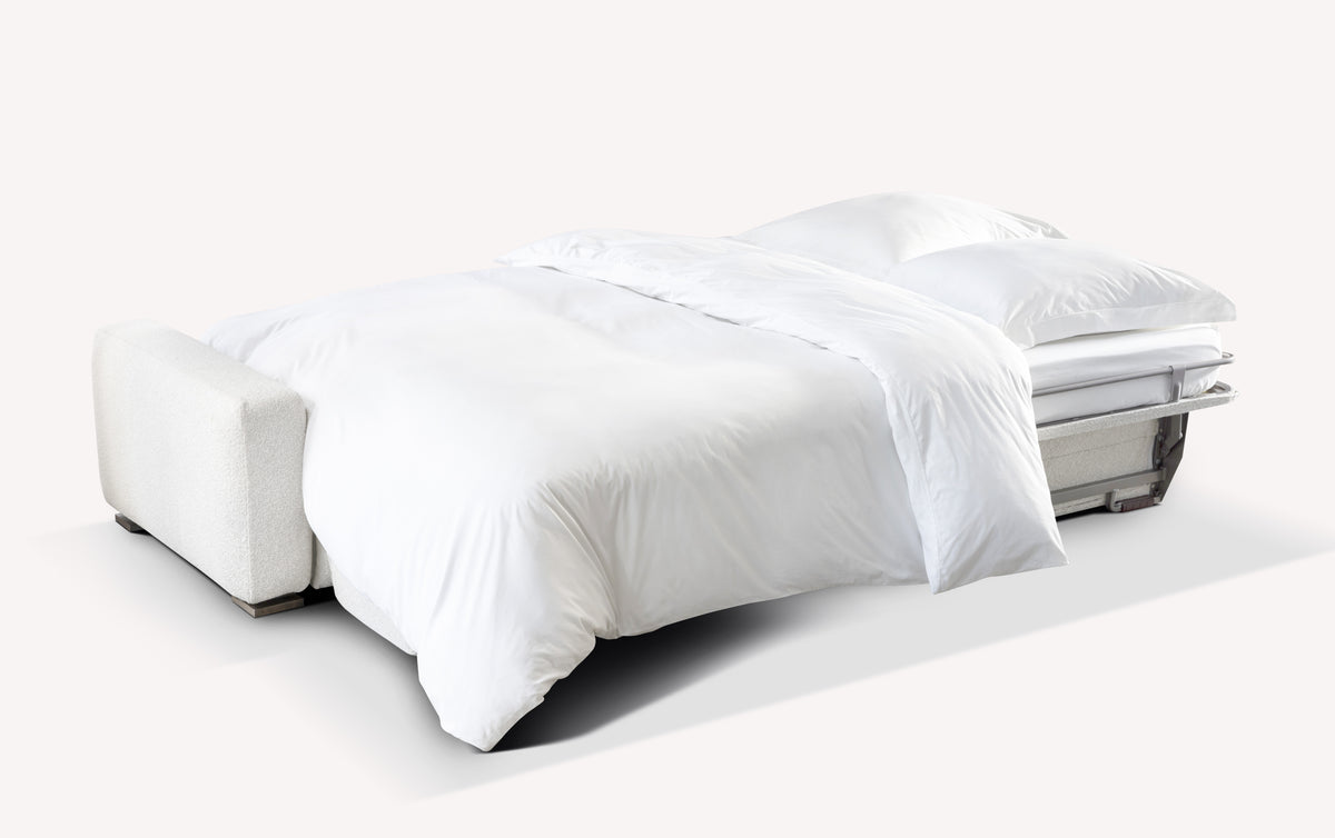 Canapé convertible en tissu ivoire avec couchage quotidien, présenté en position lit, démontrant confort et fonctionnalité dans la gamme CROSS +500 tissus & cuirs.