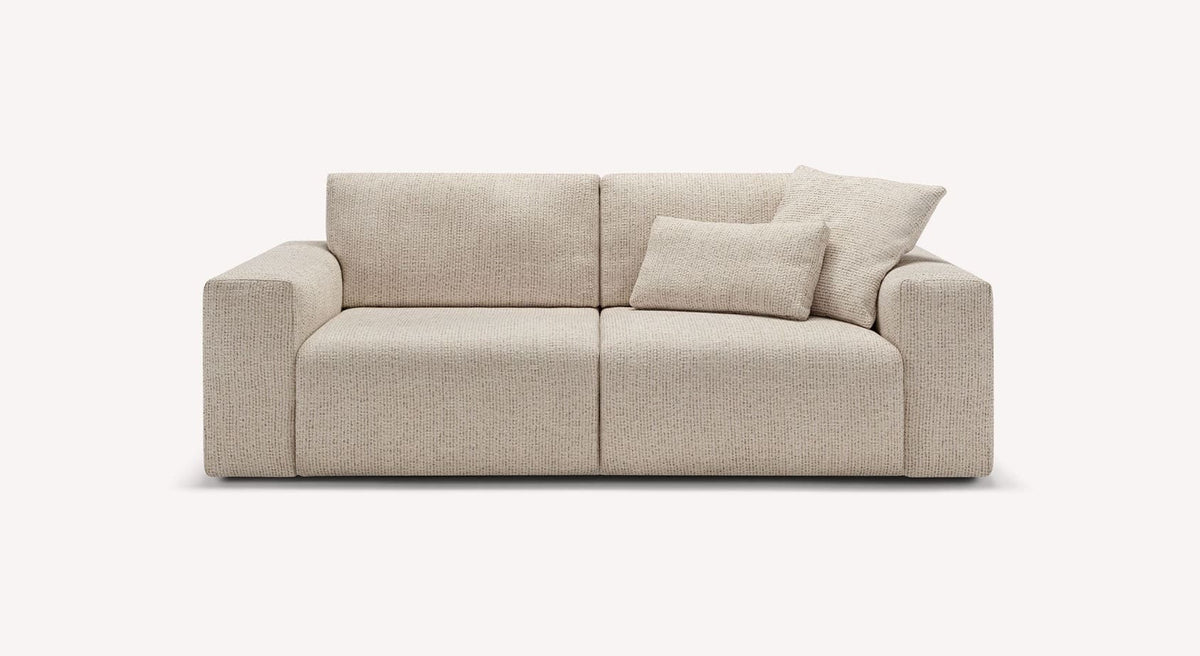 Canapé convertible DOLLY Fixe Silencio Ivoire avec lignes modernes, tissu beige clair, deux coussins décoratifs, idéal pour couchage quotidien.