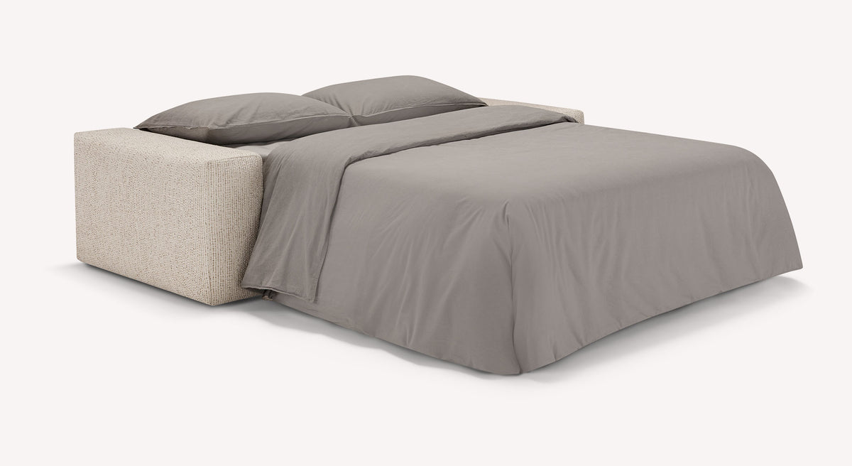 Canapé convertible DOLLY Silencio Ivoire déplié en lit avec un couchage quotidien équipé d'un vrai matelas, présenté avec literie grise douce.
