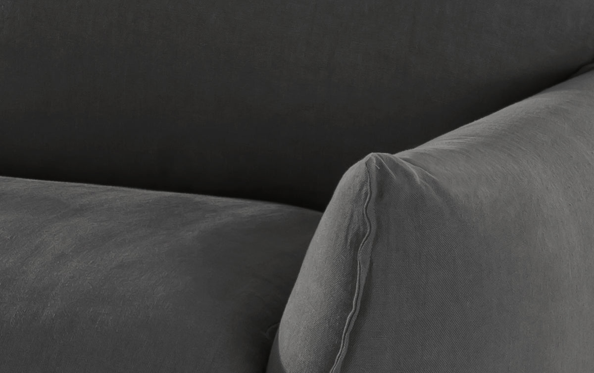 Accoudoir d'un canapé convertible en tissu gris foncé, modèle Die Elietis, avec un design moderne et élégant