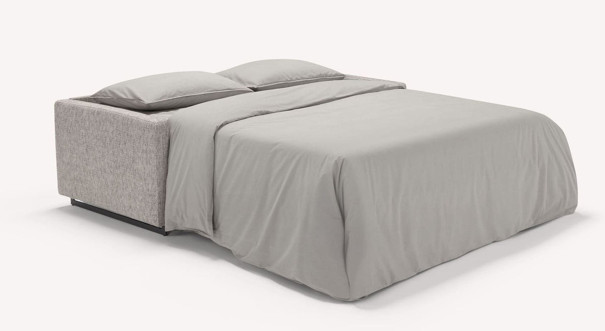 Canapé convertible JUSTIN Mariclo Etain déplié en lit avec housse de tissu gris clair, idéal pour un couchage quotidien confortable et élégant.