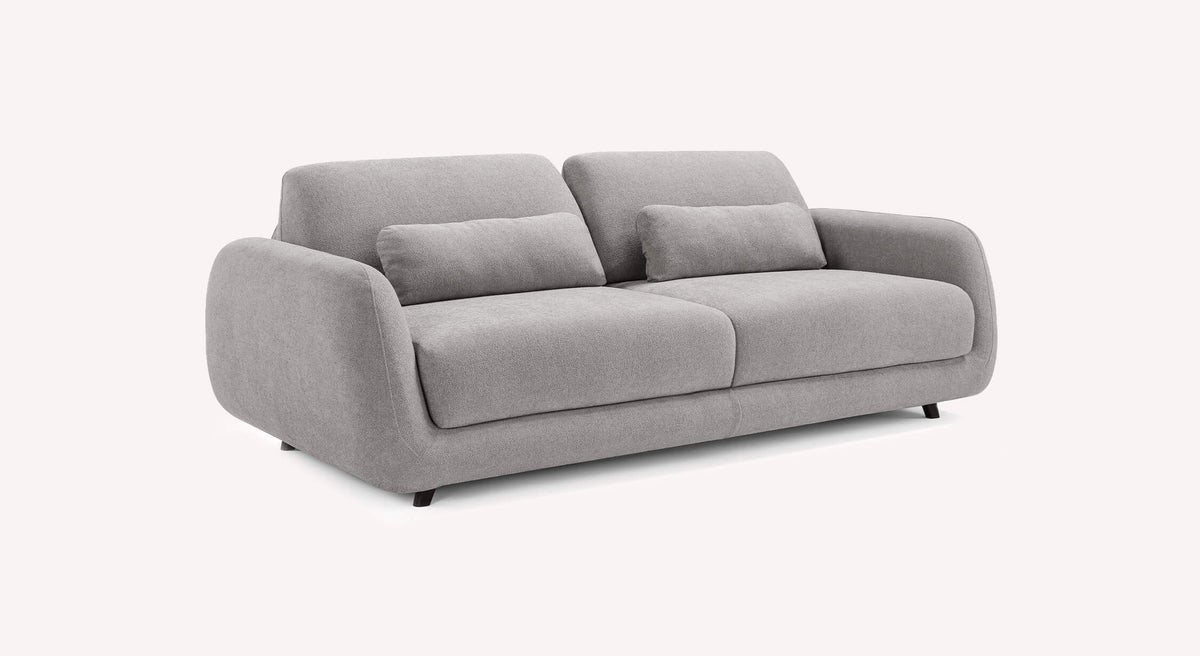 Canapé convertible MOON Innuendo Etain gris clair avec accoudoirs arrondis et coussins assortis, idéal pour un couchage quotidien confortable.
