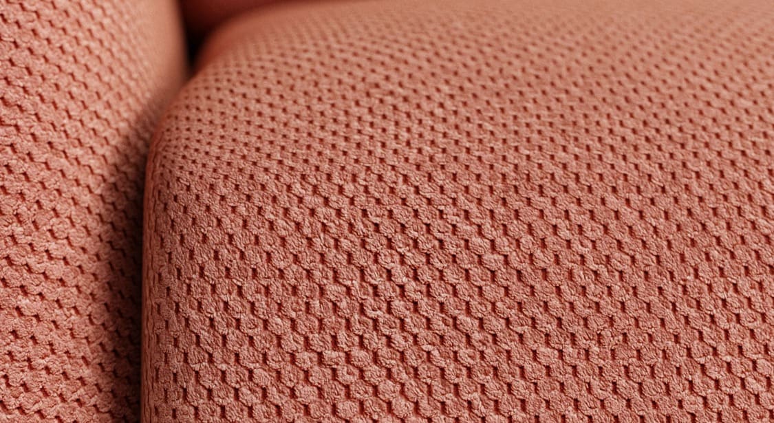 Texture en tissu corail avec motif maille hexagonale, détail du revêtement du canapé convertible MOON Moby Corail offrant un toucher doux et confortable.