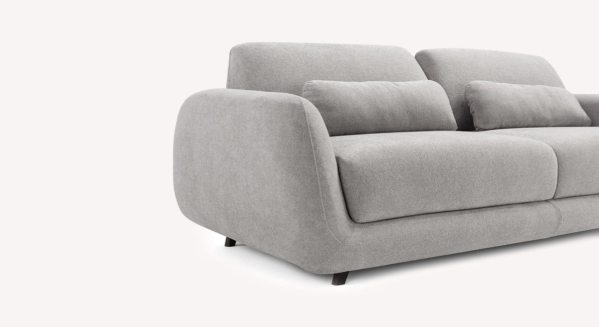 Canapé convertible MOON Innuendo Etain en tissu gris clair avec coussins assortis, design moderne aux formes arrondies, idéal pour un couchage quotidien confortable.