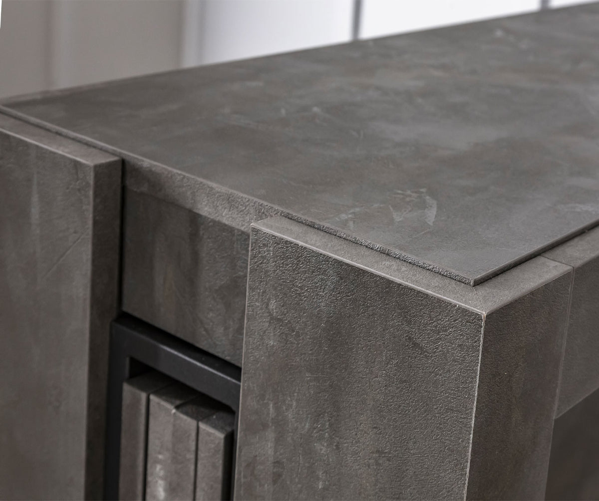 Détail en gros plan d'une table extensible avec finition effet pierre grise mettant en valeur la texture et la robustesse du COMPACT Mélaminé Pietra.