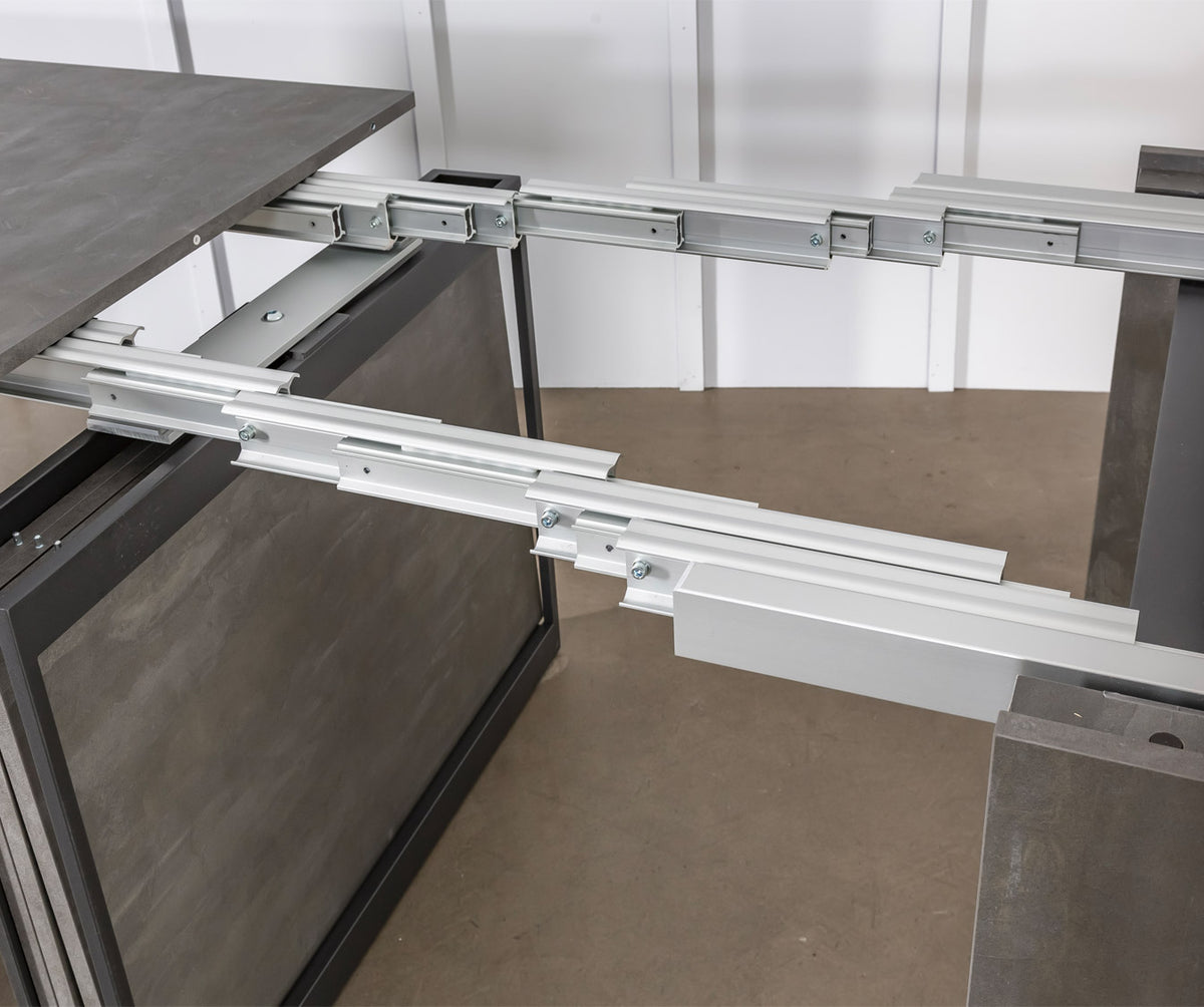Détail du mécanisme d'extension en métal de la table extensible COMPACT Mélaminé Pietra offrant robustesse et fonctionnalité pour un usage modulable et pratique.