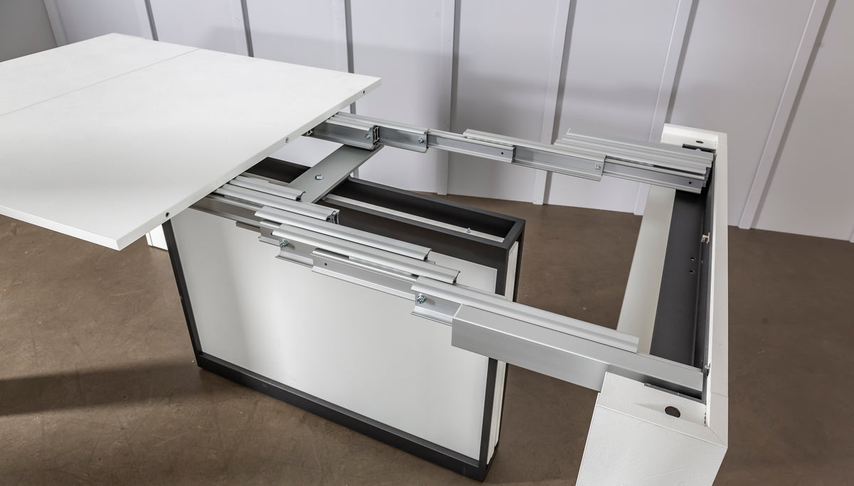 Table extensible moderne en COMPACT Mélaminé Bianco spatolato avec mécanisme d'ouverture métallique robuste, idéale pour optimiser l'espace dans un intérieur contemporain.