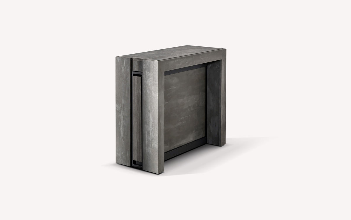 Table extensible compacte en position fermée, finition béton gris, design moderne et minimaliste