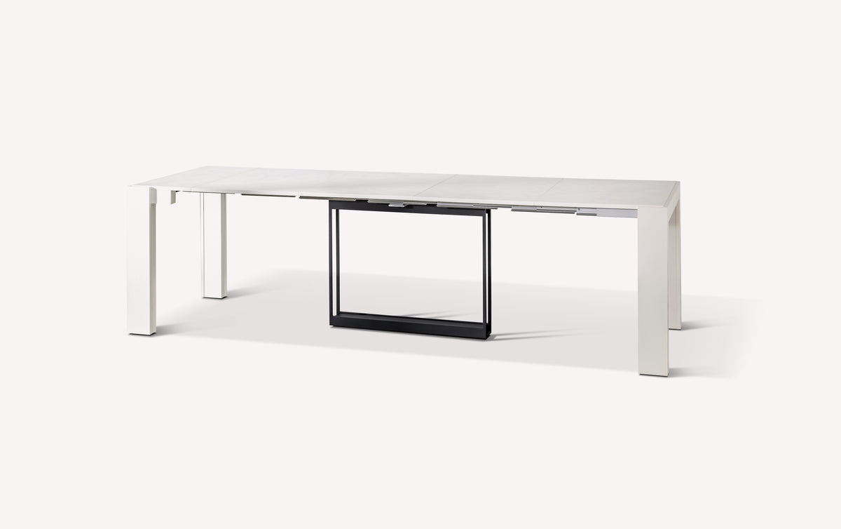 Table extensible moderne en COMPACT Mélaminé Bianco spatolato avec finition blanche et structure noire, idéale pour optimiser l'espace et accueillir plusieurs convives.