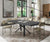 Table à manger contemporaine avec plateau foncé et pieds design en métal, entourée de chaises beiges, dans un salon lumineux avec ambiance élégante, modèle LUNGO LARGO Mélaminé Pietra.
