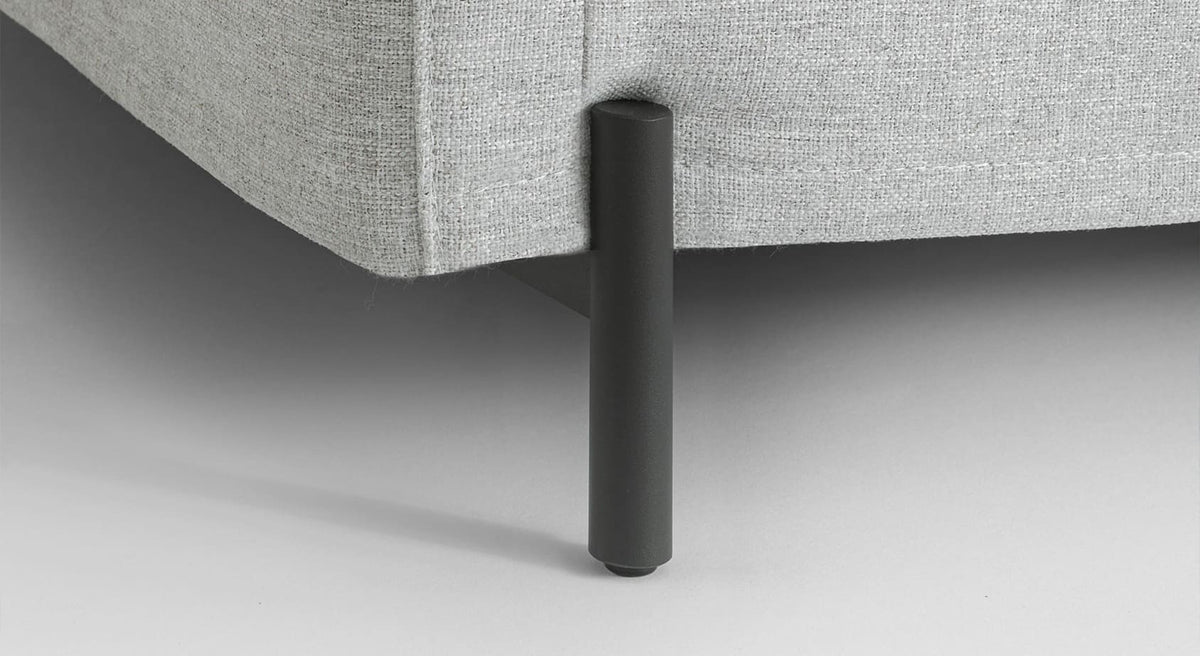 Détail du pied métallique noir soutenant un canapé convertible SERGE Tixer Silver au tissu gris clair, illustrant la qualité et la robustesse du mobilier.