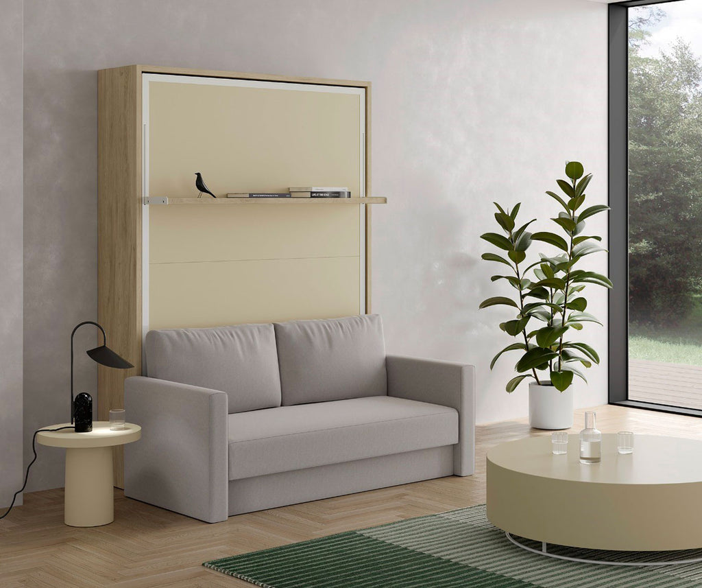 Canapé convertible devant un lit escamotable ETYA Mélaminé Roble aurora Façade biscuit Luna 31 intégré dans un salon moderne avec une table basse ronde, une lampe et une plante verte.