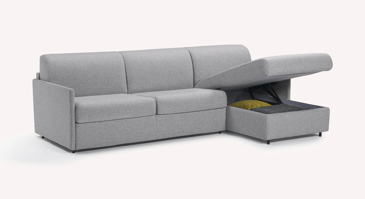 Canapé convertible d'angle Jerry compact en tissu gris Denver Silver, avec rangement ouvert contenant un coussin jaune