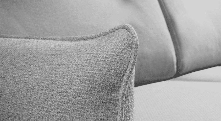 Détail en gros plan du tissu gris texturé et du coussin décoratif sur le canapé convertible TONY Barrel Etain, mettant en valeur la qualité du matériau et le confort.