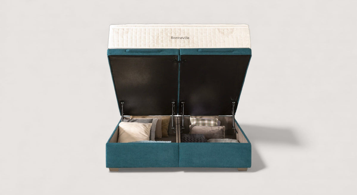 Pack CABOURG Bronx Pétrol montrant un lit coffre ouvert avec rangement de coussins et couette, tissu bleu pétrole, idéal pour canapé convertible avec couchage quotidien.