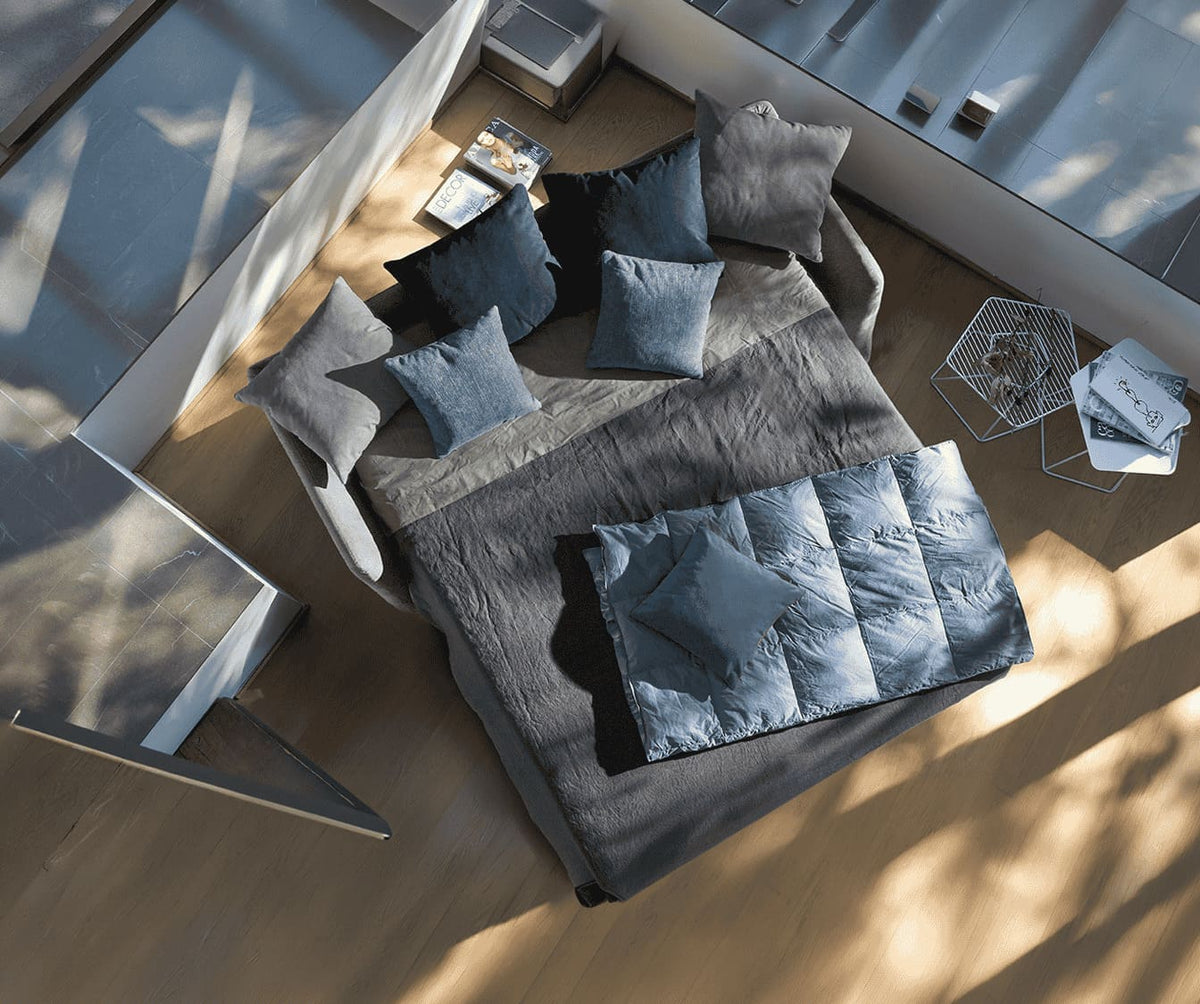 Canapé convertible LUZ Foster Silver en tissu gris nuit, déployé en couchage quotidien, avec plusieurs coussins assortis dans un intérieur lumineux et moderne.