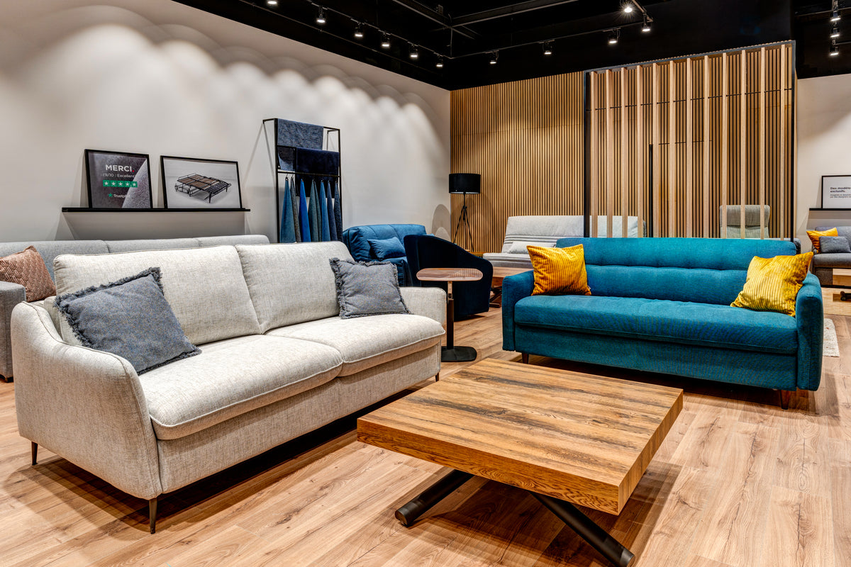 Salon d'exposition de La Maison du Convertible avec canapés modernes, table basse en bois et décorations murales, situé au 90 avenue Henri Barbusse