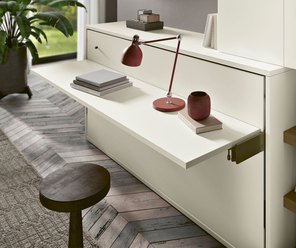 Bureau enfant en mélaminé blanc avec tablette rabattable, accompagné d'une lampe de bureau rouge et d'objets décoratifs, dans un intérieur moderne lumineux, modèle LUCY BUREAU Enfant Mélaminé Blanc.