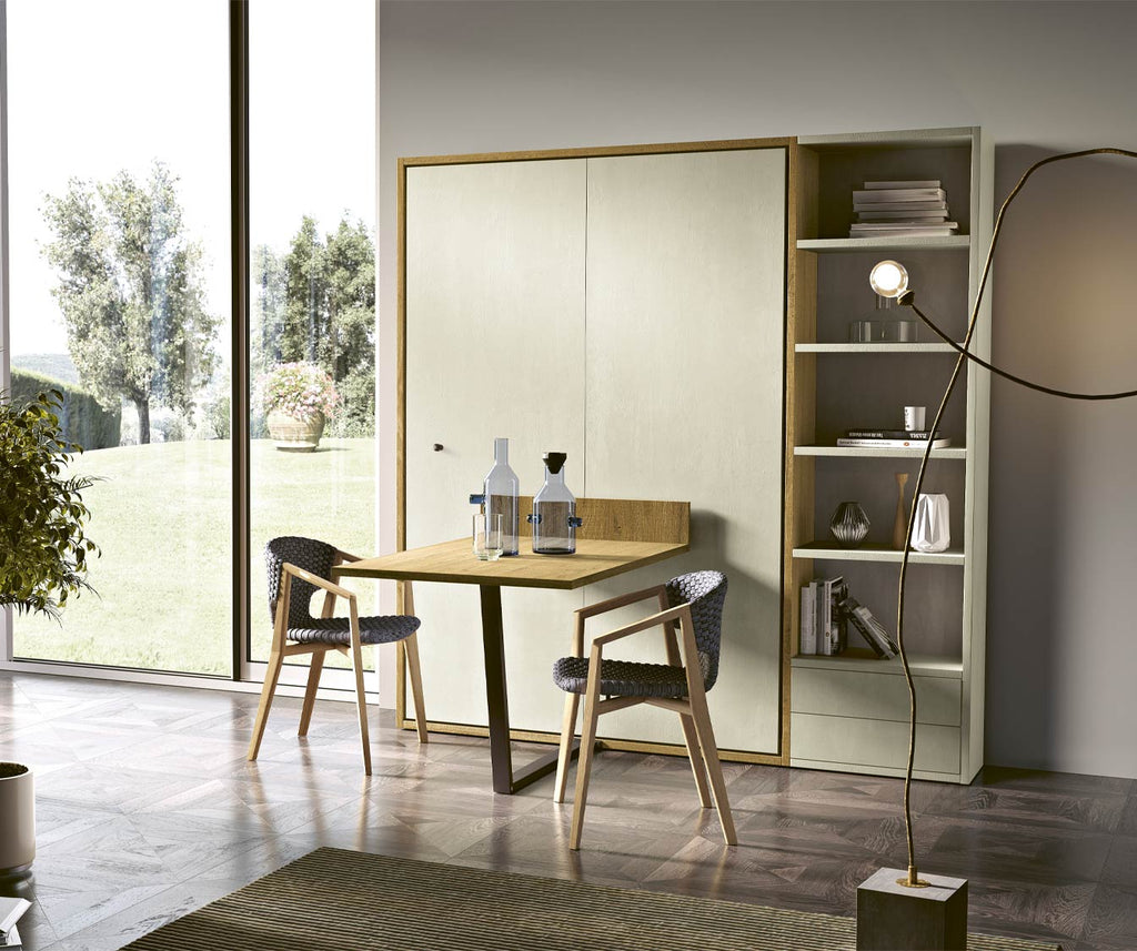 Espace repas moderne avec LUCY TABLE +50 coloris & matériaux, intégrée dans un meuble clair avec étagères ouvertes, chaises en bois et ambiance lumineuse naturelle.