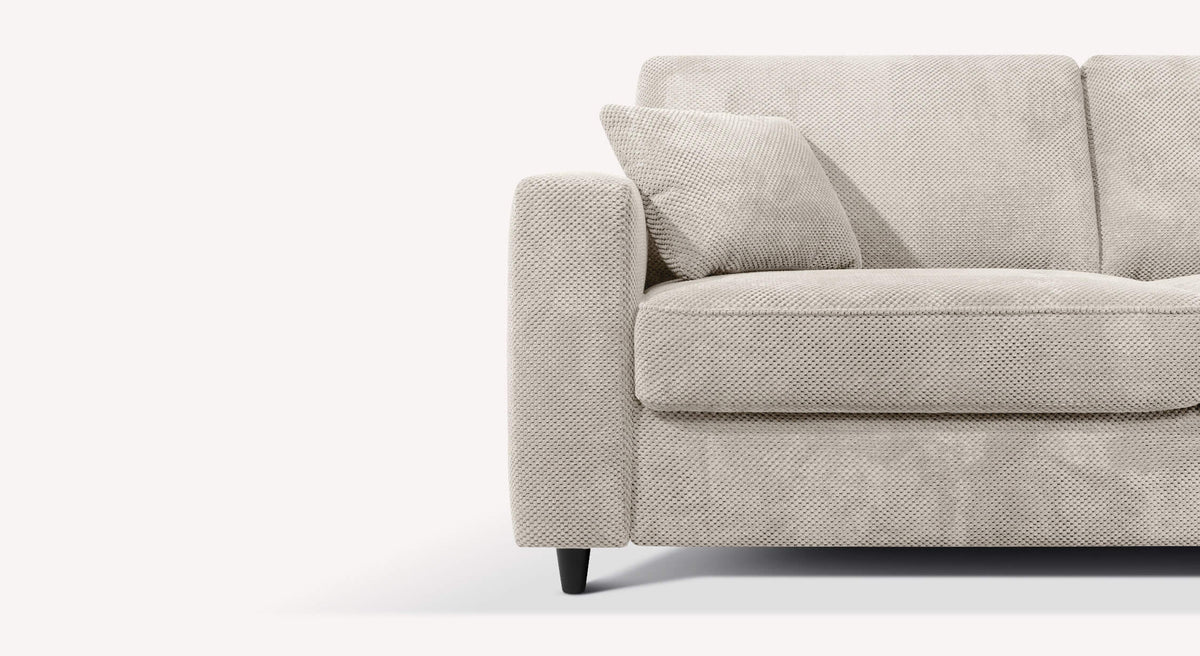 Détail en gros plan du tissu beige clair du canapé convertible ALBA Moby Avoine, mettant en valeur la texture douce et confortable pour un couchage quotidien.