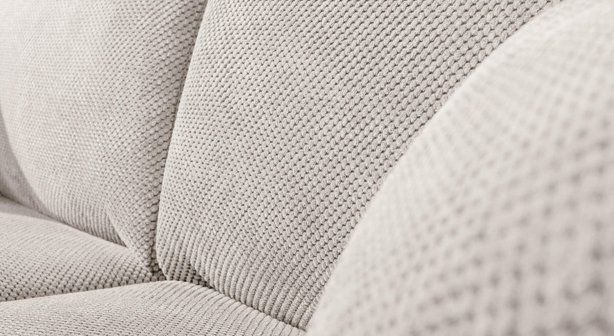 Gros plan sur le tissu texturé d'un canapé convertible Alba en tissu Moby coloris avoine