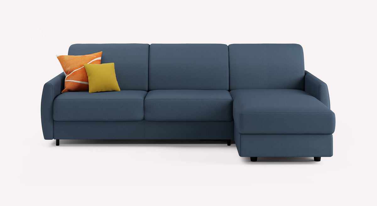 Canapé convertible d'angle en tissu bleu avec méridienne à droite, décoré de coussins orange et jaune. Modèle Alix Luna