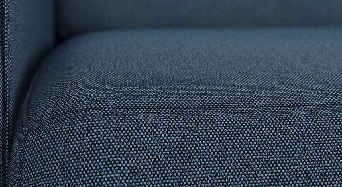 Gros plan du tissu bleu denim du canapé convertible Alix, modèle Luna, montrant la revêtement détaillée du matériau