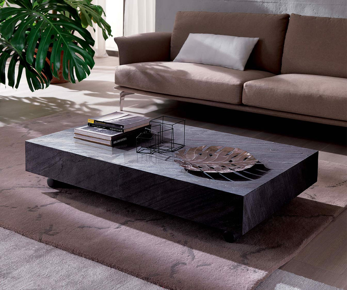 Table basse moderne avec plateau en plaque BOX LEGNO Plaqué Rovere wild bianco, décor minimaliste avec livres et plante verte à côté d’un canapé dans un salon lumineux.