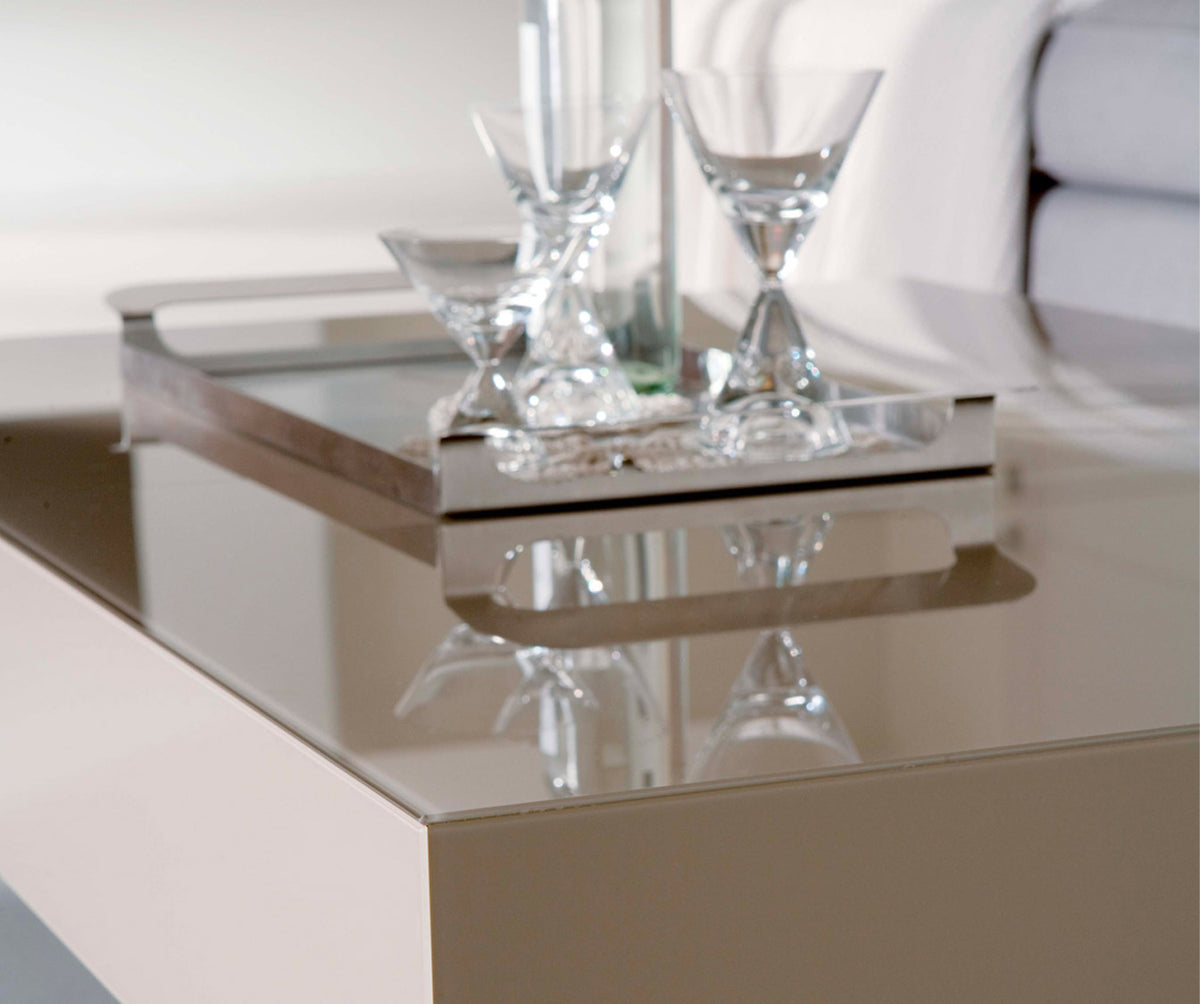 TABLE EXTENSIBLE au design épuré avec plateau en verre clair reflétant des verres élégants, illustrant la modernité et la finesse du BOX Verre Extrachiaro.