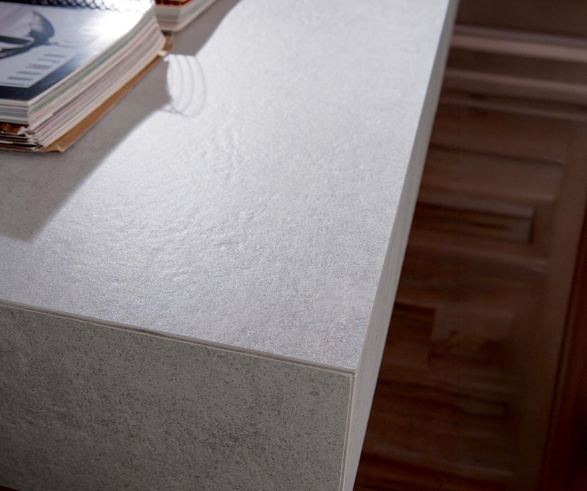 Détail en gros plan d'un angle de table en pierre grise avec une surface texturée, illustrant la finition élégante et moderne de la BOX Verre Extrachiaro.