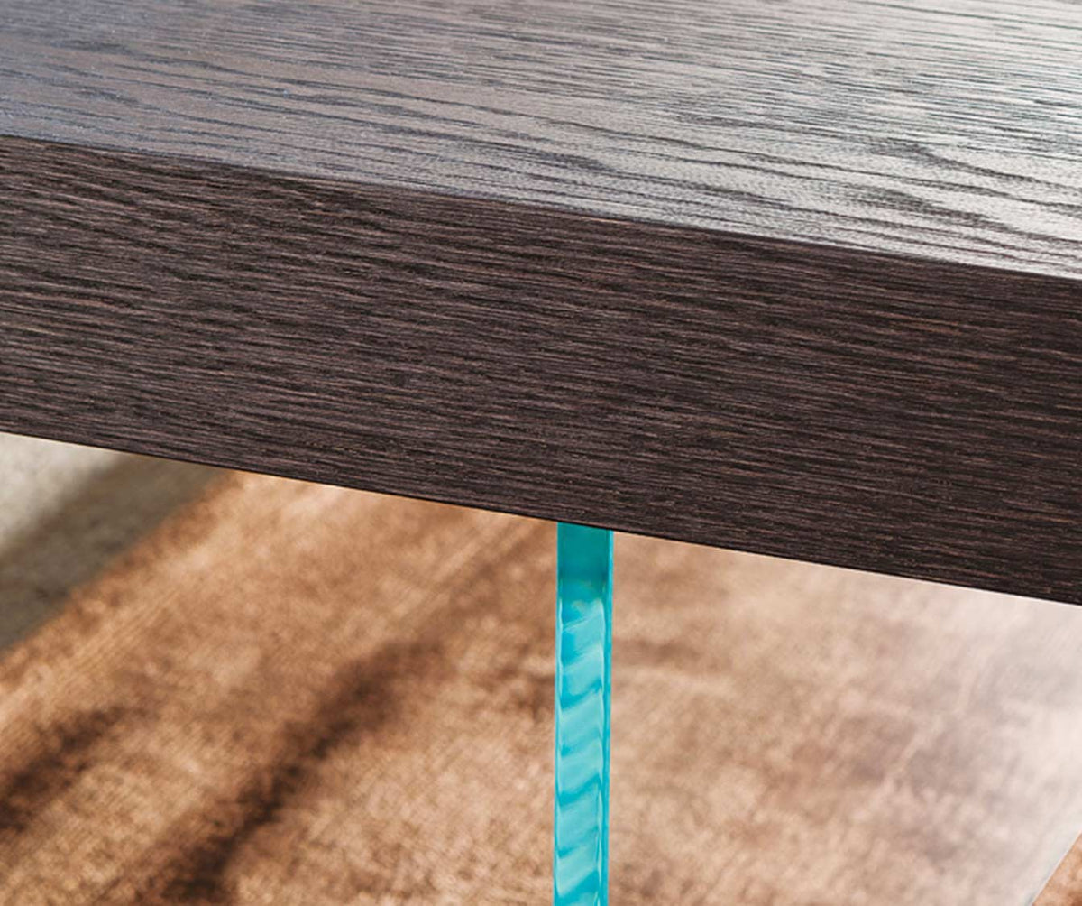 Détail d'une table extensible avec finition en MARKUS Plaqué Rovere vecchio naturale, mettant en valeur la texture bois naturel et le pied en verre transparent.