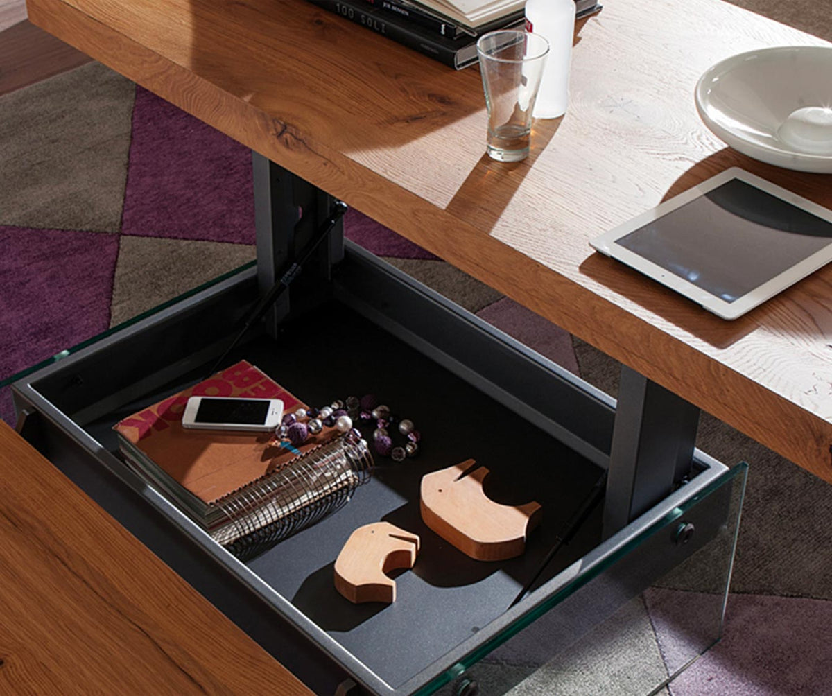 Table extensible avec rangement intégré ouvert, en bois naturel, modèle MARKUS Plaqué Rovere vecchio naturale, utilisée dans un espace moderne avec accessoires sur le plateau.
