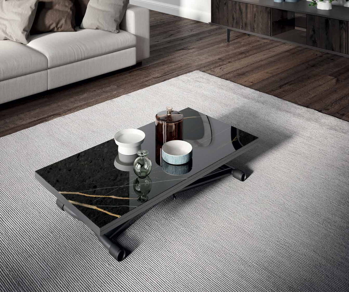 Table basse moderne avec surface en SISSY Verre Marbré Sahara noir lucido, posée sur un tapis clair dans un salon contemporain au sol en bois foncé.