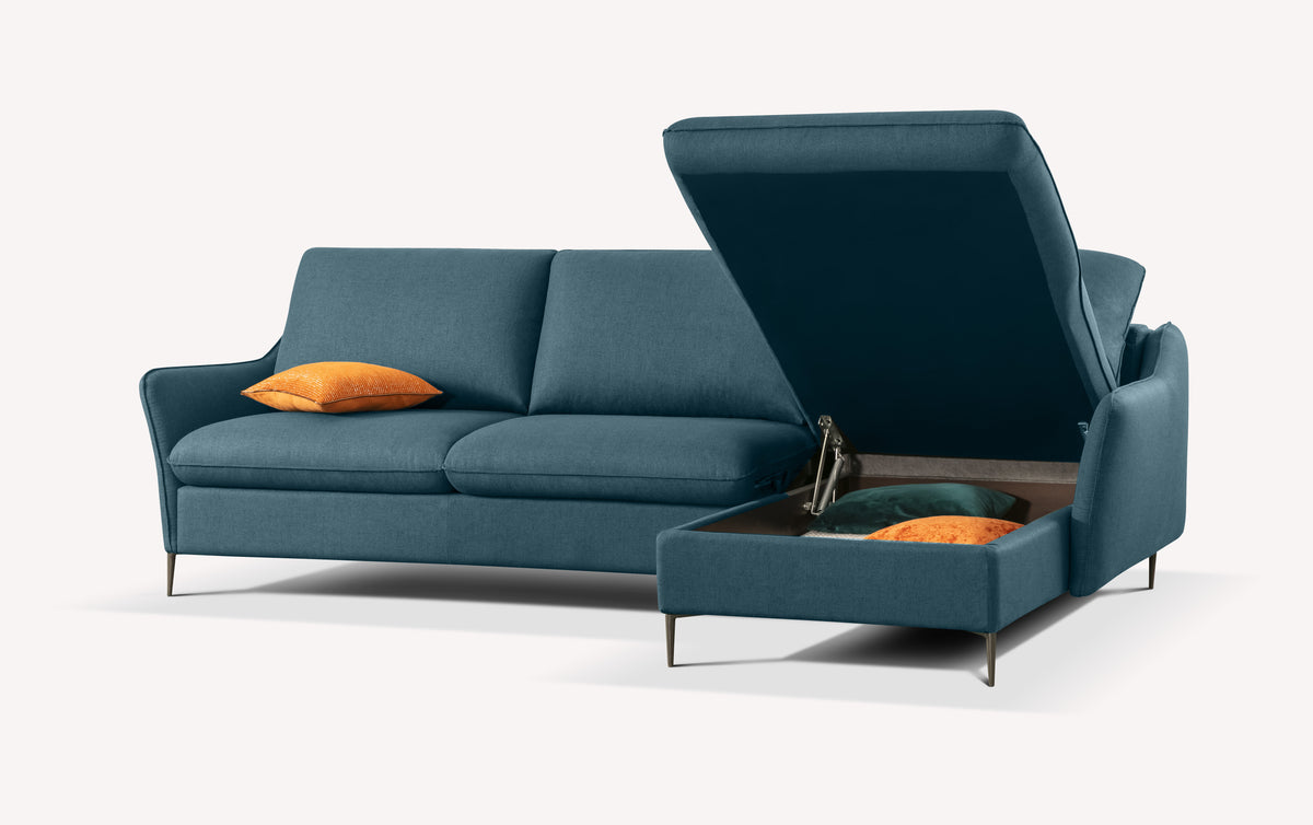 Canapé d'angle en tissu bleu océan avec coffre de rangement ouvert, contenant des coussins orange