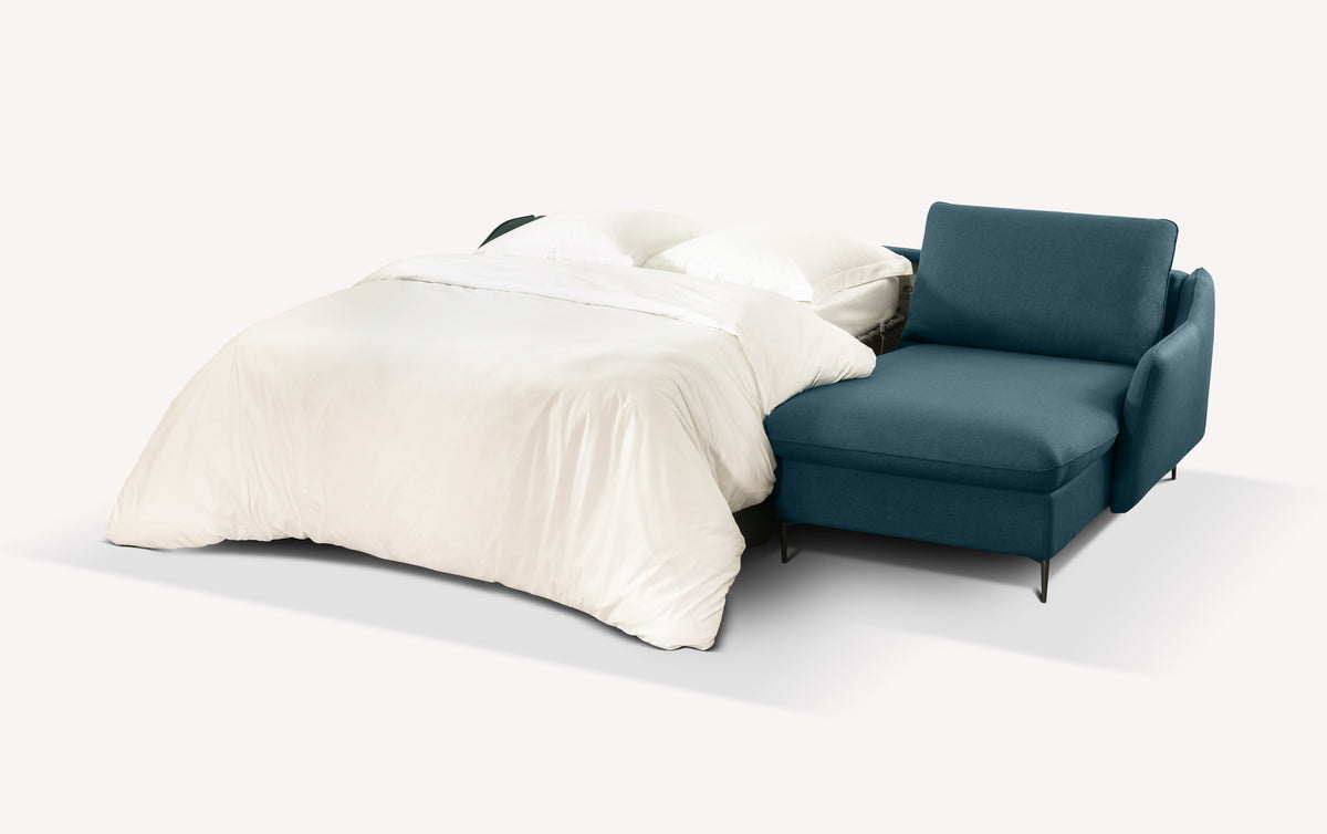 Canapé d'angle convertible en tissu bleu océan, modèle Bogart, avec lit déplié et draps blancs