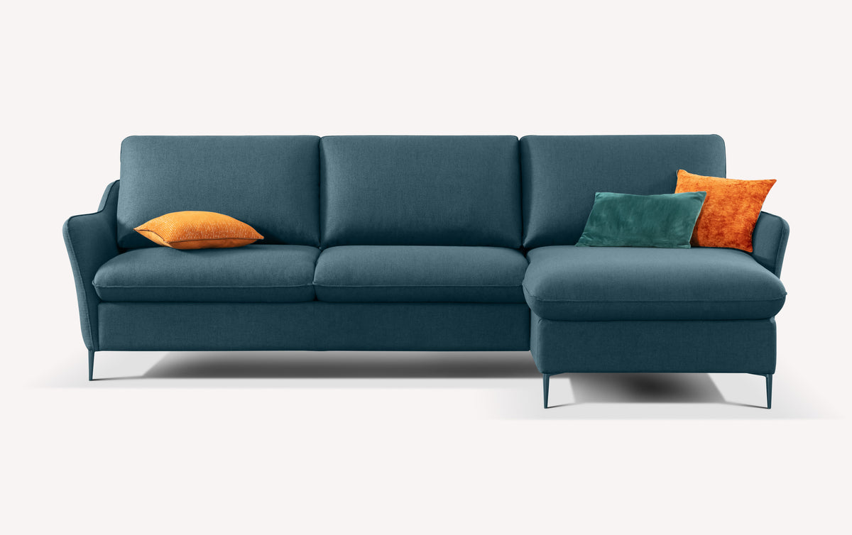 Canapé d'angle BOGART Angle Foster Bleu ocean avec revêtement tissu bleu océan, accompagné de coussins décoratifs orange et vert, design moderne et épuré.