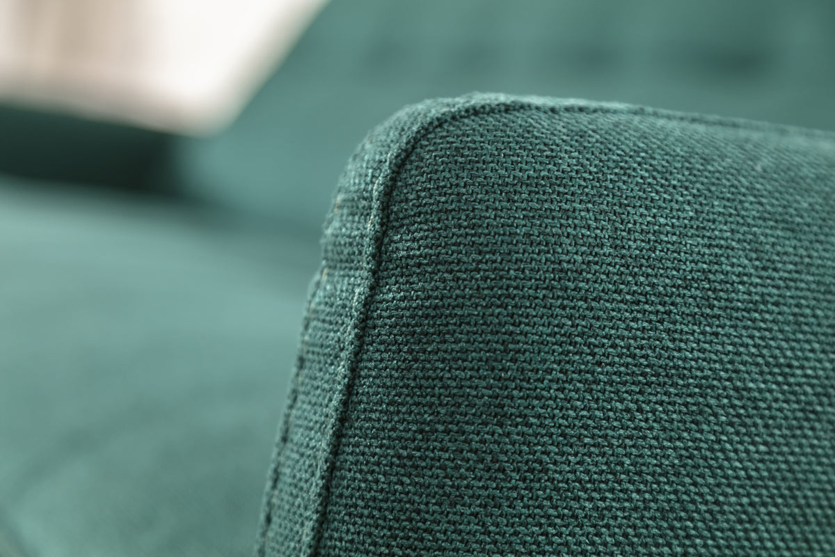 Gros plan sur l'accoudoir d'un canapé convertible en tissu Austin couleur pétrole, modèle Soho
