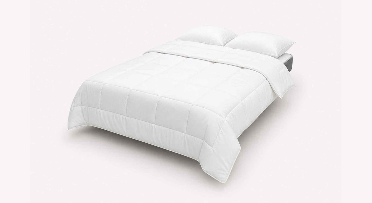 LEON Misterio Poivre un lit élégant avec une literie blanche douillette, comprenant une couette et deux oreillers, parfait pour un couchage confortable.