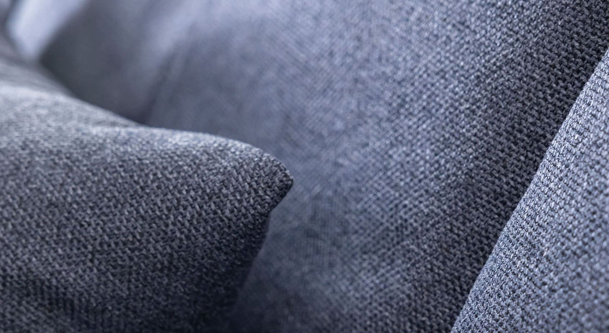 Détail en gros plan du tissu bleu profond du canapé convertible MONTRÉAL Austin Deep blue, mettant en valeur la texture douce et le coussin confortable pour un couchage quotidien.