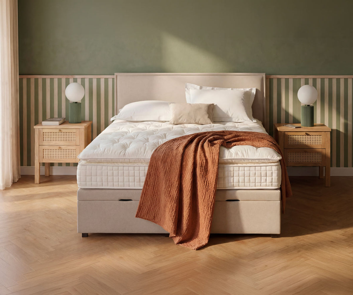 Lit coffre OUESSANT Luca Beige dans une chambre moderne avec linge de lit blanc et couverture marron, entouré de tables de chevet en bois clair et lampes design.